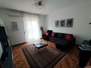 Ein Wohnzimmer mit einer Couch, einem Couchtisch, einem Teppich und Kunstwerken an der Wand.