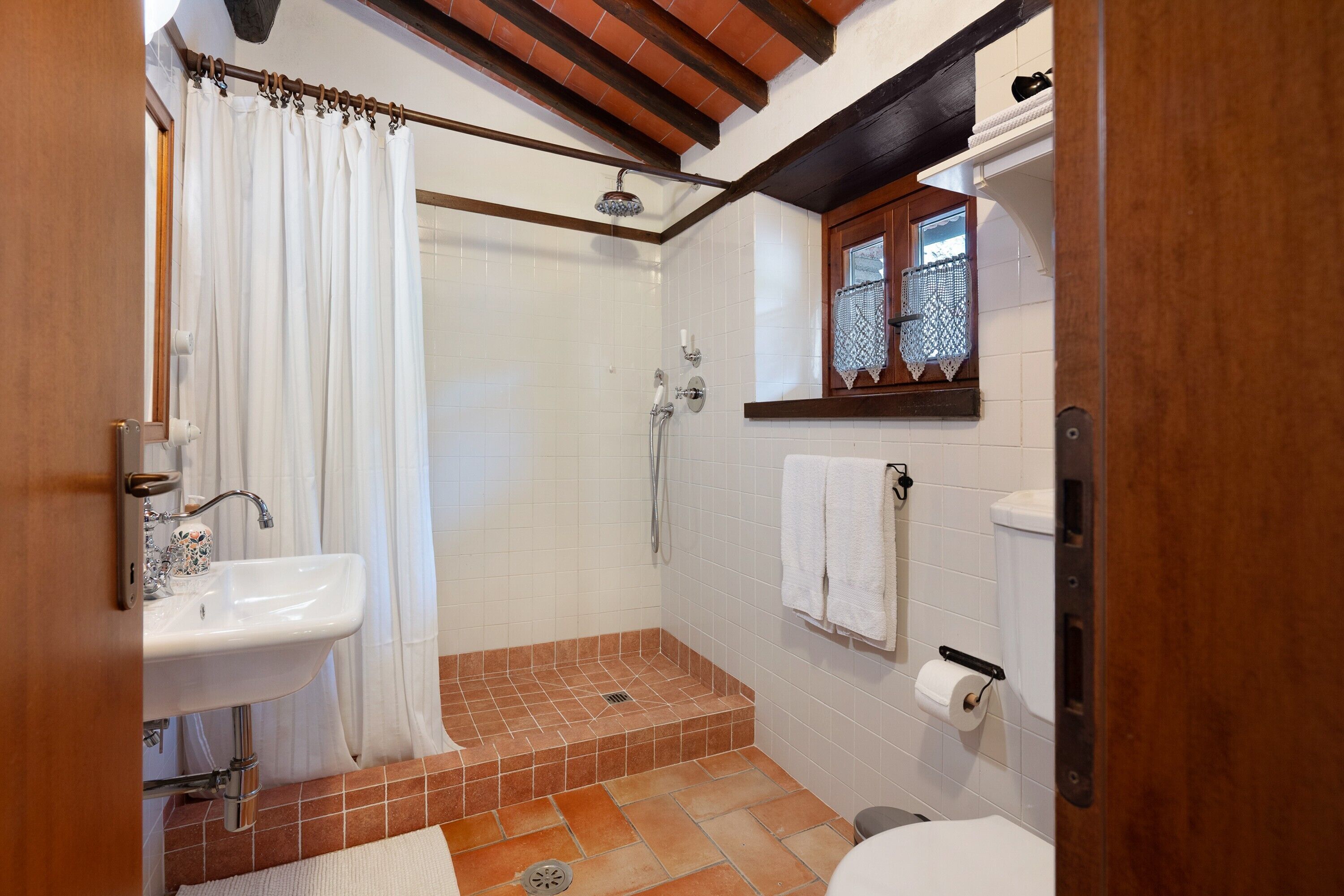 Une salle de bain avec douche, lavabo et toilettes.