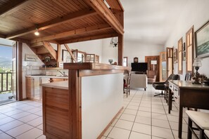 A spacious kitchen with wooden beams, a dining area with chairs, and a view of the outdoors. - Holiday Home 'Villa Sugar Town' with Sea View, Wi-Fi and Air Conditioning (?a????)