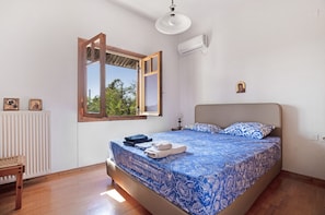 A bedroom with a bed, a window, a radiator, and a wooden floor. - Holiday Home 'Villa Sugar Town' with Sea View, Wi-Fi and Air Conditioning (?a????)