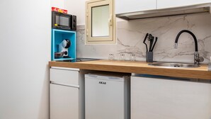 Une cuisine compacte équipée d’un four à micro-ondes, d’une machine à café et d’un évier.