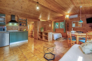 L’intérieur d’une cabane en bois comprend une cuisine, un coin repas et un espace de vie chaleureux.