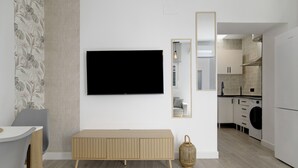 A modern kitchen with a built-in oven, a washing machine, and a dining area with a table and chairs. - Apartment 'Apartamentos Habana 4' with Air Conditioning (Barbate)
