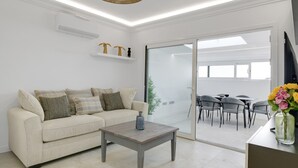Una sala de estar moderna con un sofá, una mesa de centro y un comedor con sillas y una mesa.