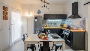 Une cuisine moderne équipée d’une table à manger pour deux personnes, d’un réfrigérateur, d’un four à micro-ondes et d’une cuisinière.