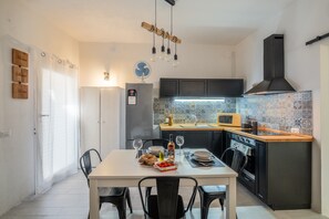 Une cuisine moderne équipée d’une table à manger pour deux personnes, d’un réfrigérateur, d’un four à micro-ondes et d’une cuisinière.