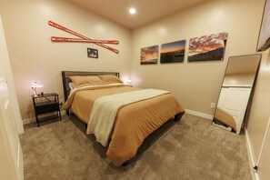 A bedroom with a bed, nightstands, and wall art. - New! Paragliding Paradise | Hot Tub | Grill | View (Draper)