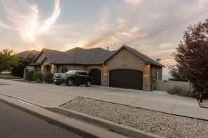 A residential house with a garage, driveway, and a parked SUV. - New! Paragliding Paradise | Hot Tub | Grill | View (Draper)