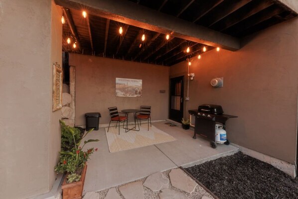 An outdoor patio with a barbecue grill, a table with chairs, and string lights. - New! Paragliding Paradise | Hot Tub | Grill | View (Draper)