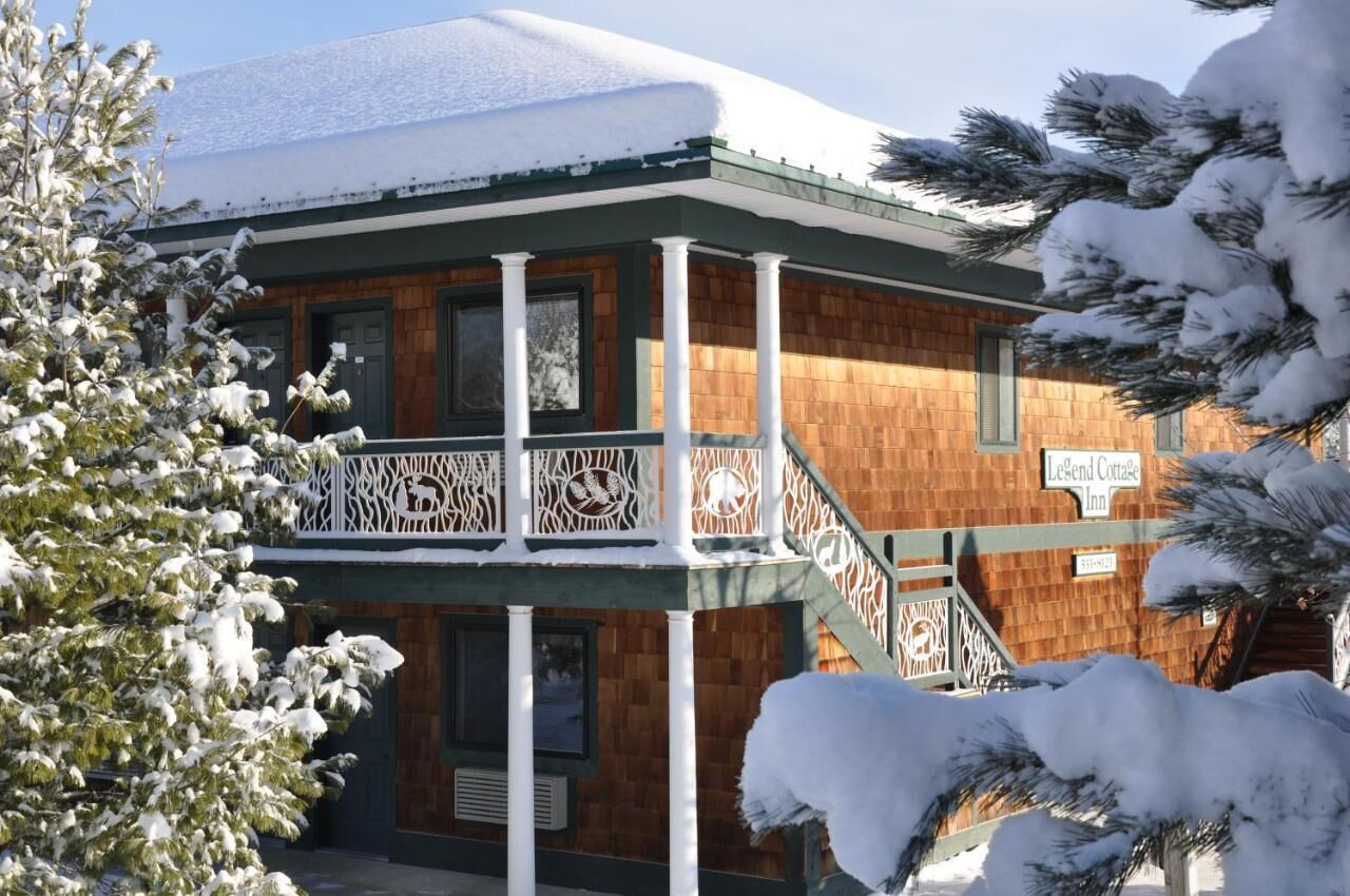 A two-story building with a wooden facade and a balcony with intricate white railings.