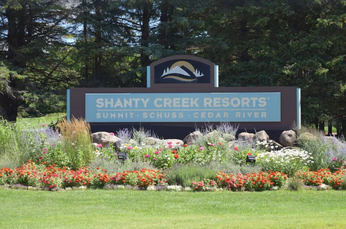 A sign for Shanty Creek Resorts with a logo, name, and location details.