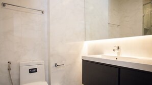 Une salle de bain moderne équipée de toilettes, d’un bidet et d’un lavabo.