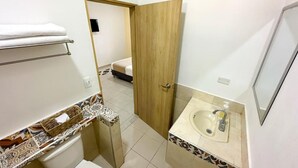 Un bany petit i funcional amb vàter, rentapel obert i barra de tovalloles.