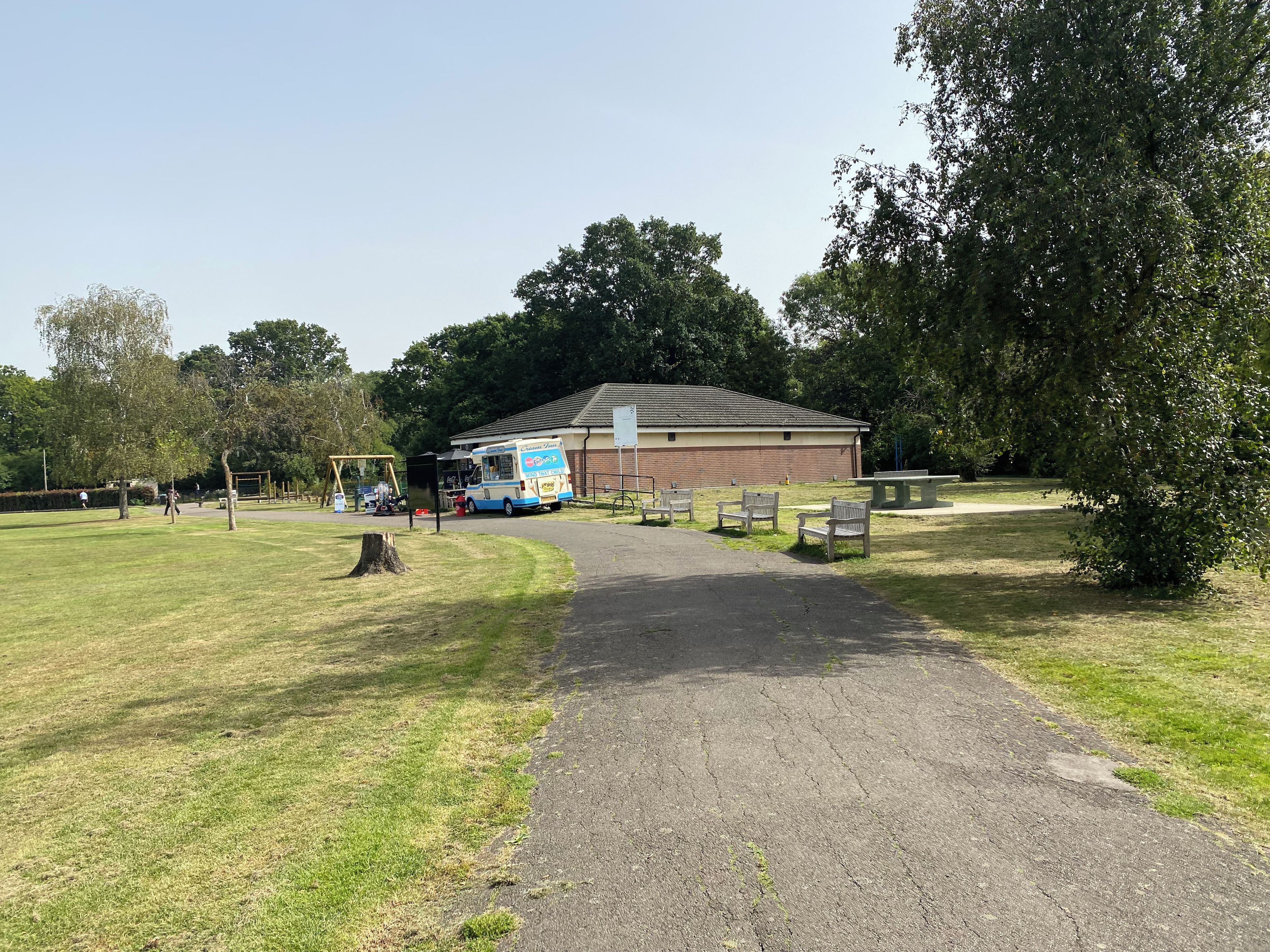 A paved pathway leading to a building with a parked food truck.