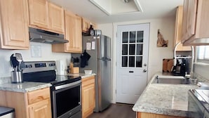 Una cocina moderna con gabinetes de madera, electrodomésticos de acero inoxidable y una isla grande con un lavaplatos.