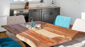 Un tavolo da pranzo con un piano in legno rustico, circondato da sedie imbottite.