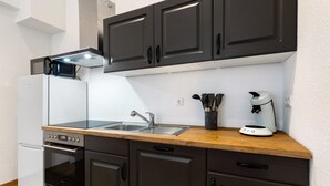 A kitchen with a built-in oven, a microwave, a sink, and a coffee maker.