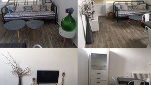 Un salon moderne comprenant un canapé, une table basse, un meuble pour la télévision et un coin repas.