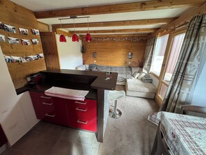 Un espacio habitable compacto con cocina, mesa de comedor y sofá.