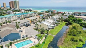A residential area with a swimming pool, a river, and a view of the ocean. - STEPS to Beach! 2B/2B, Sleeps 9! Beach, POOL, Repeat! NEW! Grill! Wagon! (Panama City Beach)