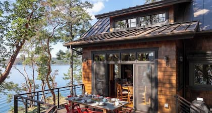 Magnificent waterfront home where sustainability meets luxury. Five private wooded acres, 400ft of rocky bluff shoreline, Chef's Kitchen, Stone Fireplaces, Heated Tile Floors & Unforgettable Sunsets over Wasp Passage. Your perfect PNW escape awaits.