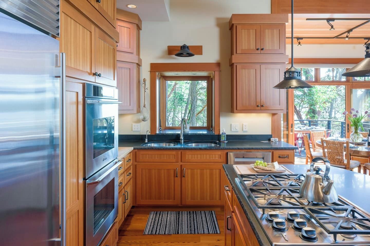 Una cocina moderna con armarios de madera, electrodomésticos de acero inoxidable y una isla grande con estufa a gas.