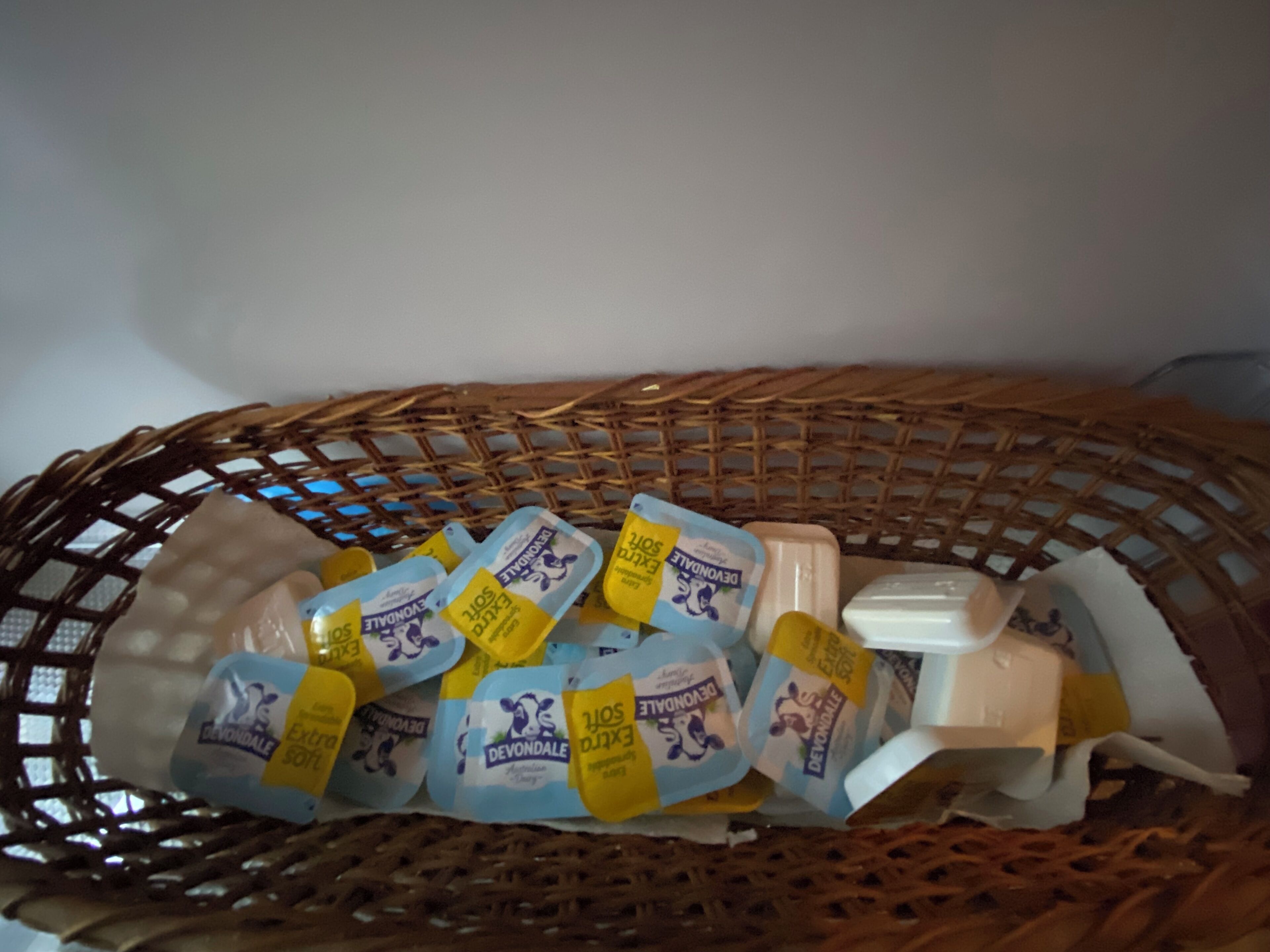 A wicker basket containing several packages of Devondale soap and a bar of soap.