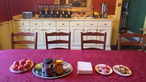 Un comedor con una mesa dispuesta para cuatro personas, mostrando diferentes platos y condimentos.