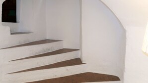 A white staircase with brown steps leading up to a window. - Vacation home Danese by Interhome (Civezza)