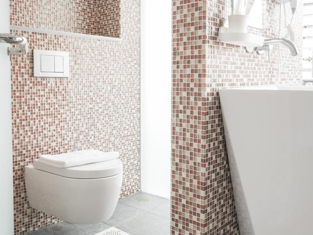 A bathroom with a toilet, a sink, and a shower area.