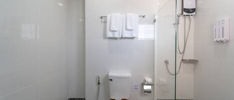 A modern bathroom with a toilet, a glass shower enclosure, and a towel rack.
