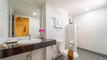 Un baño moderno con lavamanos blanco, inodoro y zona de ducha.