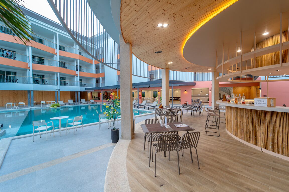 Area piscina interna moderna con diversi livelli, zone relax e una reception.