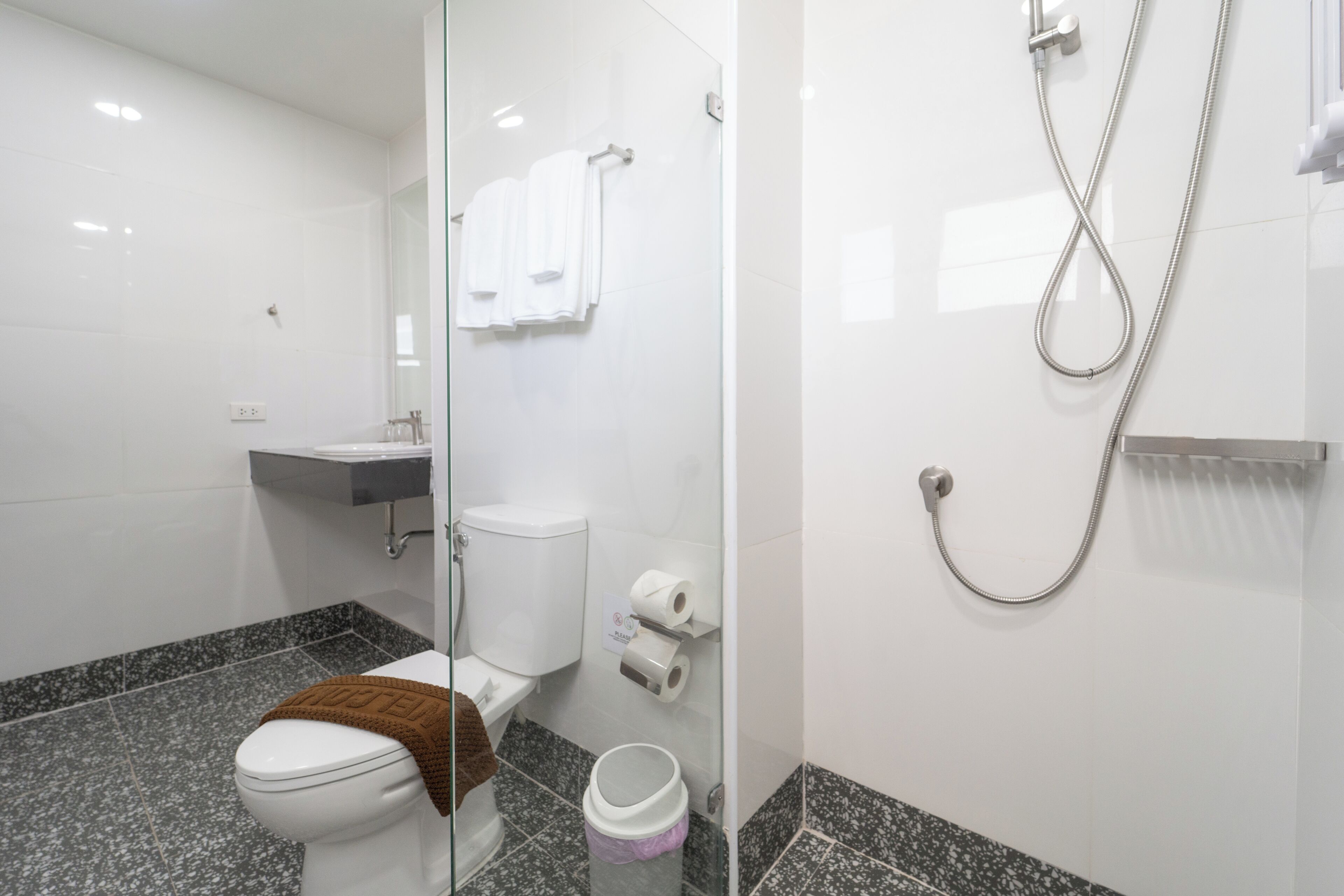 Un baño moderno con inodoro, lavamanos y ducha.