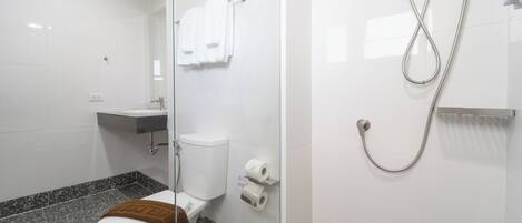 A modern bathroom with a toilet, sink, and shower.