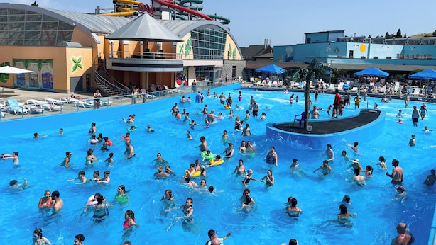A large swimming pool with multiple lanes and a water slide in the background. - Dreamvilla tbilisi (Tbilisi)