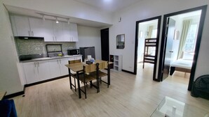 Een knus woongedeelte met een kitchenette, een eethoek en een slaapkamer.