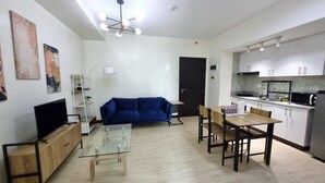 Een modern appartement met een zithoek, een eettafel en een keuken.