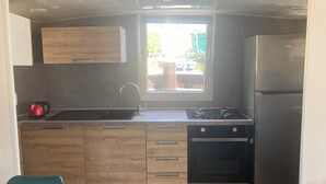 A compact kitchen with a sink, stove, and refrigerator. - Péniche Marie-lou (Thourotte)