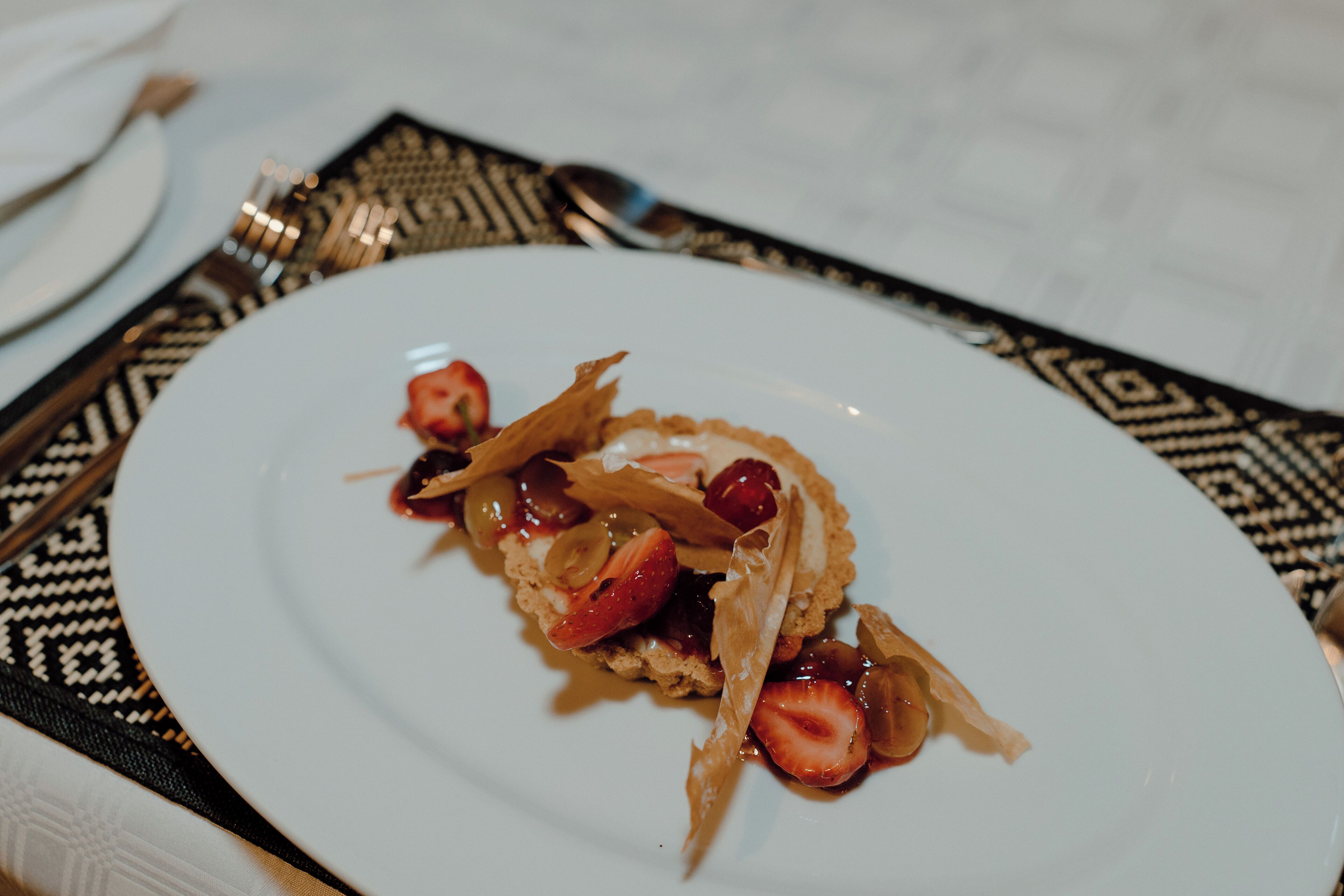 A plate with a dessert on a white plate, placed on a black and white patterned placemat.