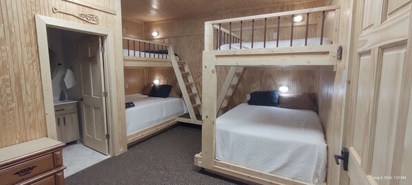 A wooden cabin with bunk beds, a wardrobe, and a desk. - Spacious lodge with custom bunk rooms in prime Lake Area with ample parking. (Waubay)