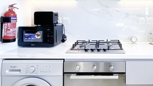 A modern kitchen with a built-in oven, a microwave, a gas stove, and a dishwasher. - Luxurious 1-br Apt With Balcony in Azizi Fawad (Dubai)