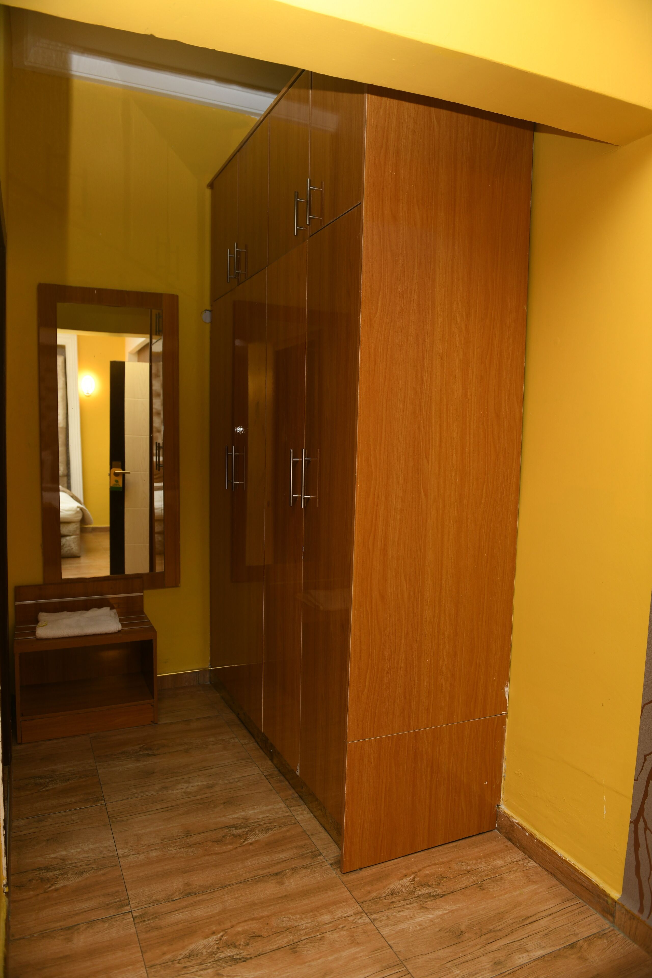 A hallway with wooden wardrobes and a bench.