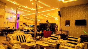 A hotel lobby with a modern design, featuring a bar area, seating arrangements, and a chandelier. - Portland Resort Hotel (Port Harcourt)