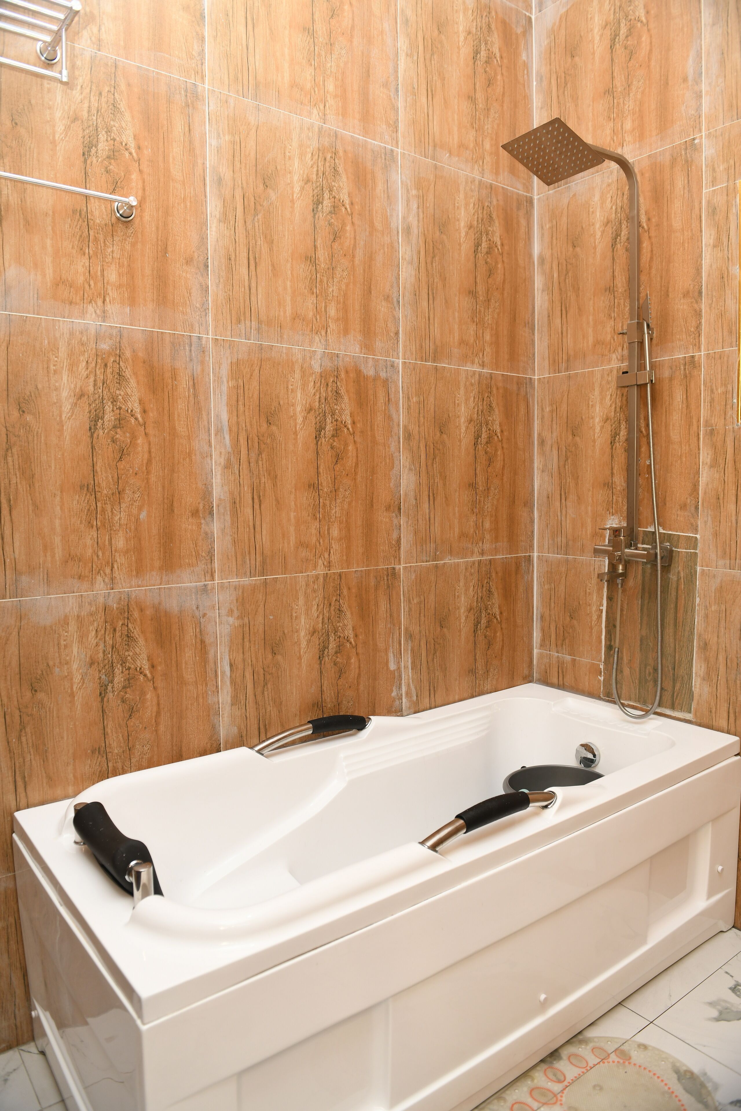 A bathroom with a white bathtub, a shower head, and a handheld shower attachment.