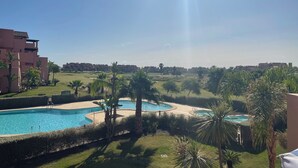 A resort with a swimming pool, palm trees, and a clear sky. - Casa Golf Mar Menor, Peace, Space, Sun and Stunning Views (MC)