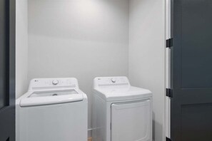 A laundry room with two white washing machines.