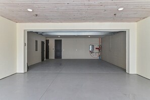 Un'ampia area interna con pavimento in cemento, soffitto in legno e stipite in metallo.