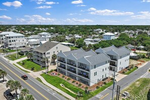 A residential area with modern two-story houses, a clear road, and a green landscape.