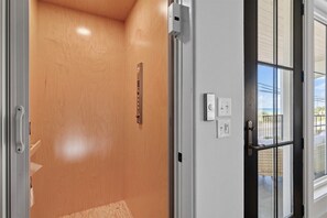 A door with a wooden panel interior, a metal handle, and a glass door with a metal frame.